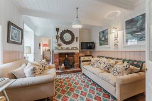 a living room with two couches and a fireplace at Quay Corner - Norfolk Cottage Agency in Cley next the Sea