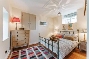 a bedroom with a bed and a dresser at Quay Corner - Norfolk Cottage Agency in Cley next the Sea