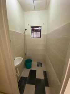 a bathroom with a sink and a toilet and a window at Air-conditioned Home in Davao City