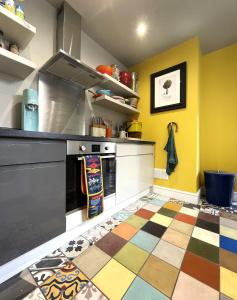 cocina con paredes amarillas y suelo colorido en Cosy period Bristol property with spacious garden, en Bristol