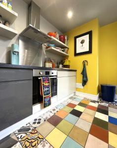 a kitchen with yellow walls and a colorful floor at Cosy period Bristol property with spacious garden in Bristol