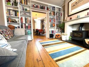 Cosy period Bristol property with spacious garden في بريستول: غرفة معيشة مع أريكة ومدفأة