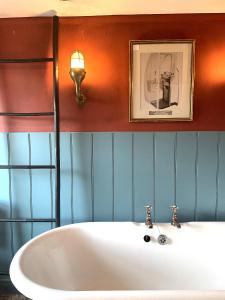 baño con bañera blanca y una foto en la pared en Cosy period Bristol property with spacious garden, en Bristol