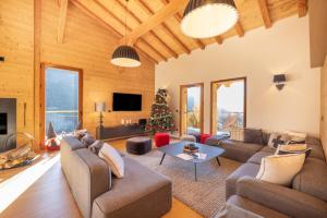 a living room filled with furniture and a christmas tree at Chalet Les Galetas du Mont Blanc in Hauteluce