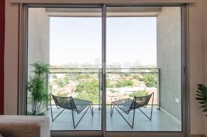2 sillas en un balcón con vistas a la ciudad en Extraordinary Apartment In Villa Morra, en Asunción