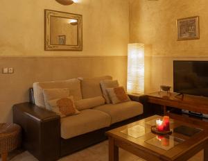 uma sala de estar com um sofá e uma televisão em Casa Rural Beit Shalom em Hervás