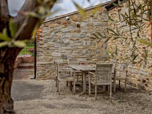 a wooden table and chairs in front of a stone wall at 3 bed in Taunton KIBOR in Trull
