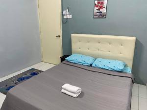 - un lit avec 2 serviettes assises au-dessus dans l'établissement MS HOMESTAY, à Arau