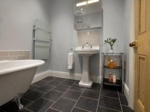 een badkamer met een wastafel en een bad naast een wastafel bij 4 Bed in Elvington 55738 in Elvington