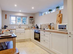 a kitchen with white cabinets and a microwave at 1 bed property in Bradford-On-Avon 82251 in Bradford on Avon