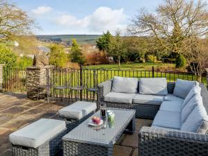 a patio with a couch and tables on a patio at 7 bed in Exford MONKH in Exford