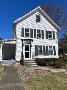 a white house with black shutters and a garage at Litchfield Modern Farmhouse in Litchfield