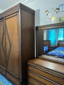 Jad apartment في إربد: غرفة نوم مع سرير وخزانة مع مرآة