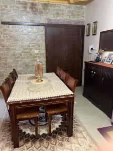 Jad apartment في إربد: طاولة طعام مع كراسي ومصباح عليها