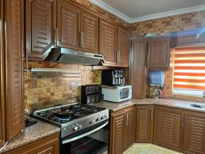a kitchen with wooden cabinets and a stove top oven at Jad apartment in Irbid