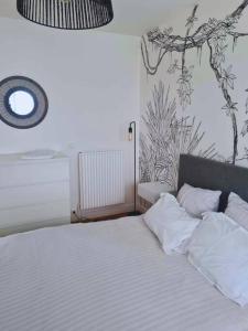 a bed with white sheets and pillows in a bedroom at T4 proche de tout ! Séjour parfait garanti in Saint-Herblain