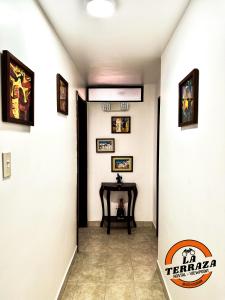 a hallway with a table and pictures on the walls at Hostal La Terraza - Roof Terrace Overlooking The North and Historic Centre in Quito