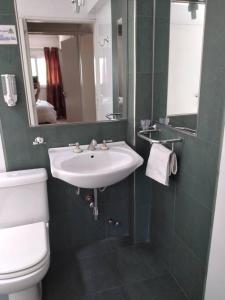 uma casa de banho com um lavatório, um WC e um espelho. em ALBERDI centro MENDOZA em Mendoza