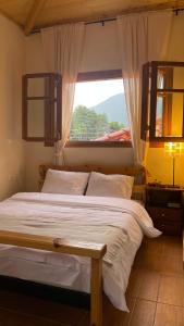 a bedroom with a large bed with a window at Loukia's Place in Vitina