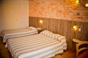 a room with two beds in a room with at Hotel Les Pins in Hourtin