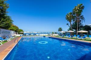 uma grande piscina com cadeiras e guarda-sóis em One bedroom apartment with beautiful pool, breakfast included em Los Realejos