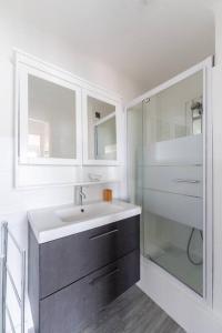 ein Bad mit einem Waschbecken und einer Glasdusche in der Unterkunft Vue mer Plage Catalans Vieux Port Clim - 2 chambres in Marseille