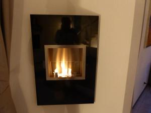 a fireplace on a wall with a person in the background at Villa Beach & Golf in Julianadorp