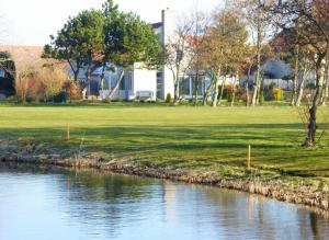 a body of water next to a grassy field at Villa Beach & Golf in Julianadorp +55 photos
