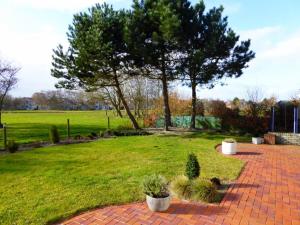 a brick walkway with a tree in a park at Villa Beach & Golf in Julianadorp