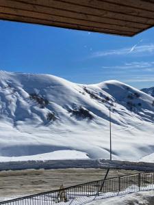 een met sneeuw bedekte berg met een persoon erop die loopt bij New Gudauri Loft 2 in Goedaoeri