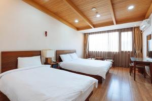 a hotel room with two beds and a desk at Damyang Spa and Tourist Hotel in Damyang