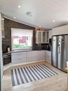 a kitchen with white cabinets and a stainless steel refrigerator at Taivalviiri in Taivalkoski