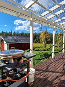 a bbq grill on a deck under a pergola at Taivalviiri in Taivalkoski