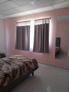 a bedroom with a bed and a mirror and a window at departamento familiar, Tarija te espera!! in Tarija