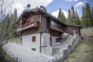 a wooden house with stairs in front at Holiday home in Campo Carlo Magno 24162 in Madonna di Campiglio