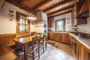 a kitchen with a wooden table and wooden cabinets at Holiday home in Campo Carlo Magno 24162 in Madonna di Campiglio