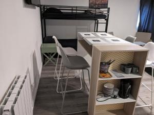 a desk and chair in a room with a bunk bed at "Aux Portes de CDG" in Thieux