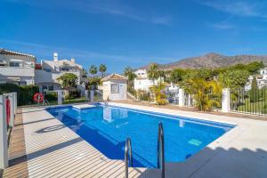 內爾哈的住宿－19C Las Palmas Oasis de Capistrano，一座位于别墅内的游泳池,别墅的背景是群山