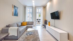 uma sala de estar com um sofá e uma televisão em Apartamenty Sun & Snow Grunwaldzka em Sopot