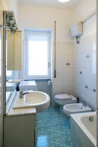 een witte badkamer met een wastafel en een toilet bij AURELIA LORIS HOUSE in Rome