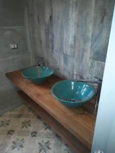 baño con 2 lavabos azules en una encimera de madera en TuArriendoCL-Llanquihue CondWerner Casa con Acceso a Hermosa Laguna, en Llanquihue