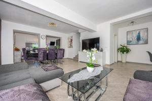 a living room with a couch and a table at VILLA NINA MALINSKA 150m FROM THE BEACH, SWIMMING POOL in Vantačići