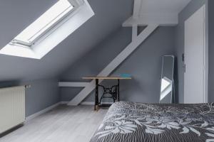 - une chambre mansardée avec un lit et une table dans l'établissement Gîte spacieux, lumineux et très cosy, à Lautenbach