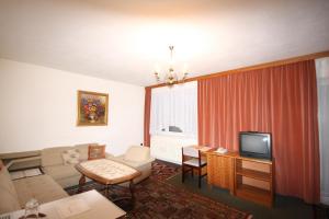ein Wohnzimmer mit einem Sofa und einem TV in der Unterkunft Drei Quellen Hotel Kipper in Bad Gams