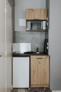 uma pequena cozinha com um lavatório e um micro-ondas em Studio centre ville Bourges em Bourges