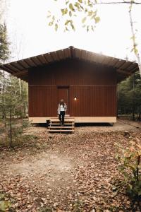 a woman is standing in front of a building at Chalet Mauricie, La Tuque in La Tuque