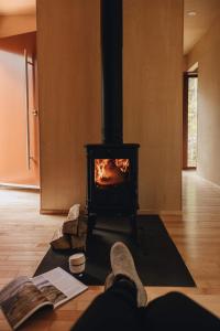 a person laying on the floor in front of a stove at Chalet Mauricie, La Tuque in La Tuque