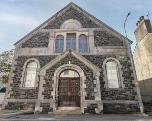 an old brick church with a brown door at The Church in Holyhead