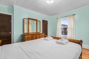 ein Schlafzimmer mit einem großen Bett mit zwei Handtüchern darauf in der Unterkunft Enchanting Echoes: Oasis Near the Falls in Niagara Falls