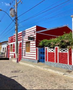 a red white and blue building on a street at Pousada Caminhos da Chapada in Palmeiras